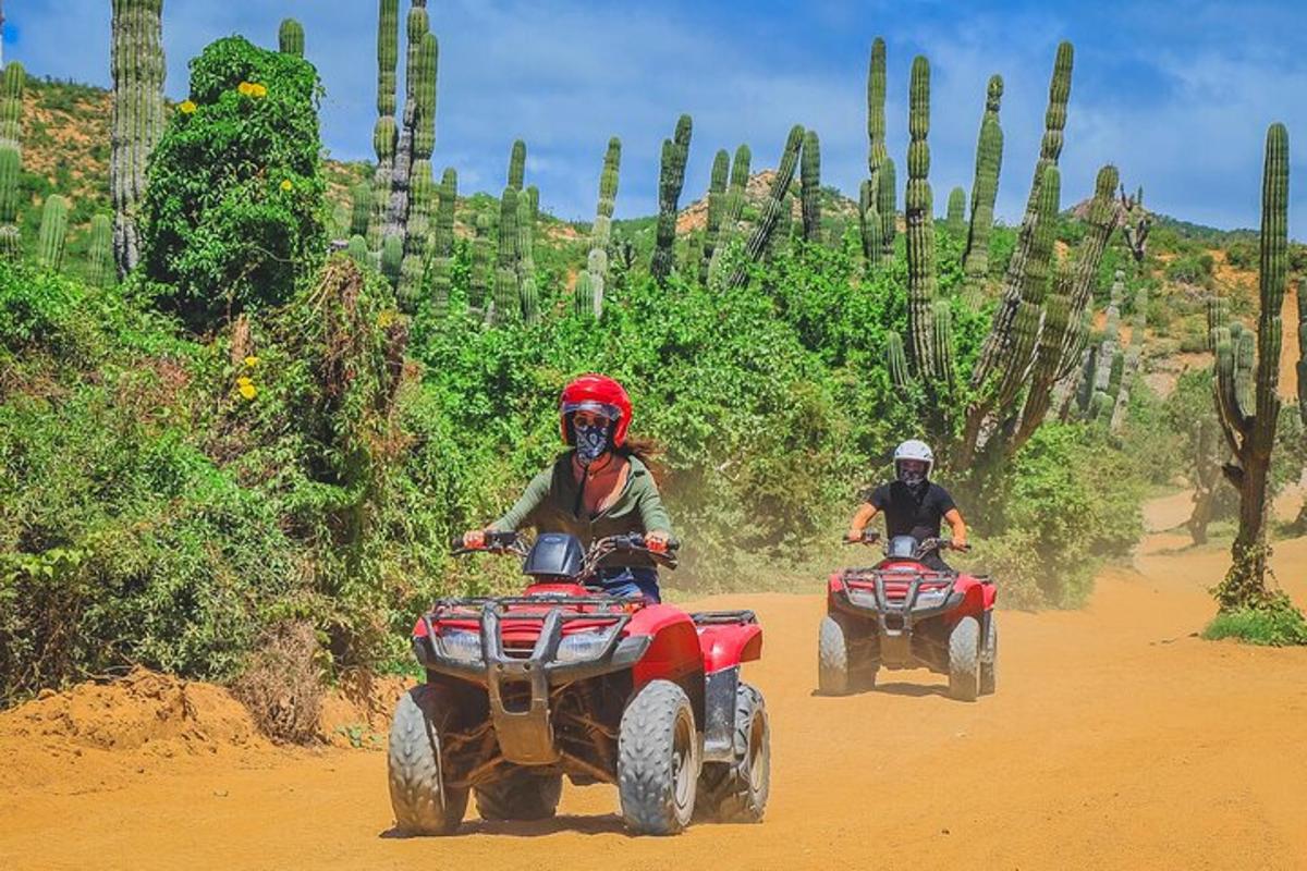 kaks inimest sõidavad ATV-dega kruusateel