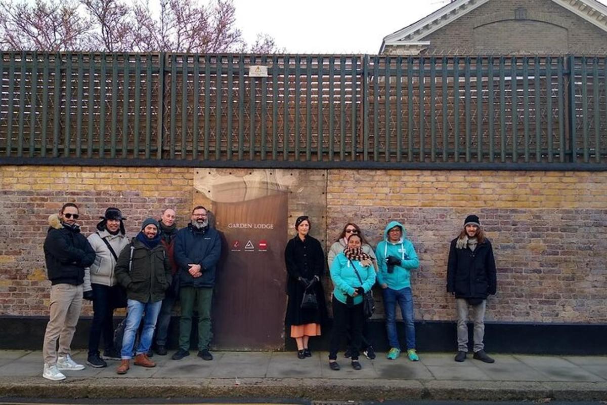 un gruppo di persone in piedi davanti a un muro di mattoni