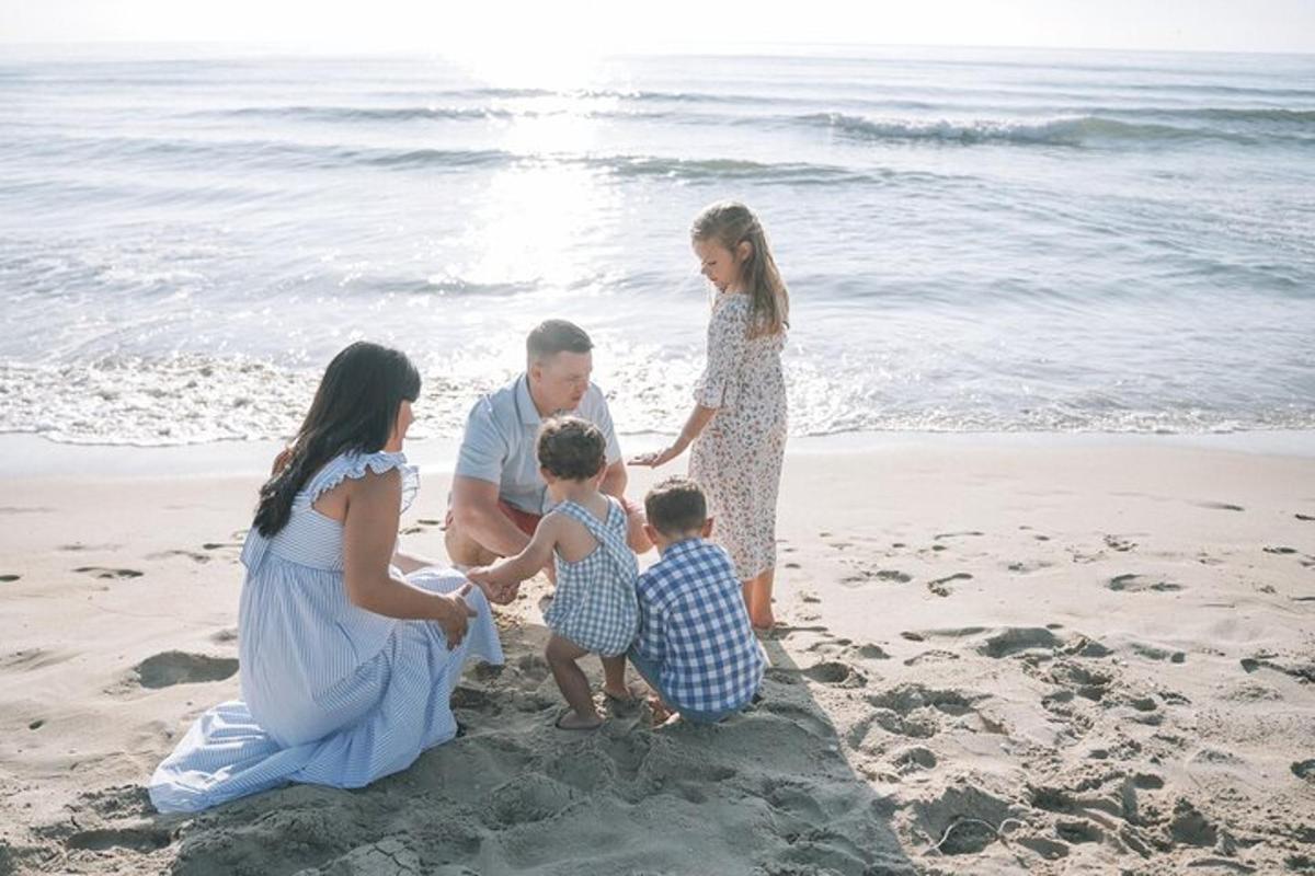 uma família brincando na areia da praia