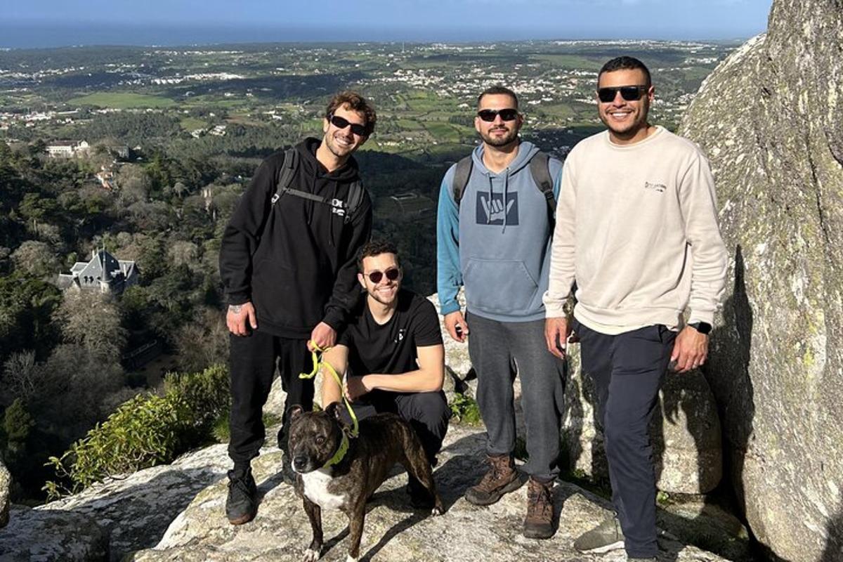 un grup de persones i un gos dret sobre una roca