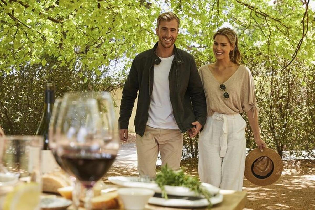 رجل وامرأة يقفان بجانب طاولة مع كؤوس النبيذ