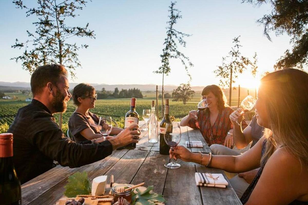 a group of people sitting around a wooden table with wine glasses