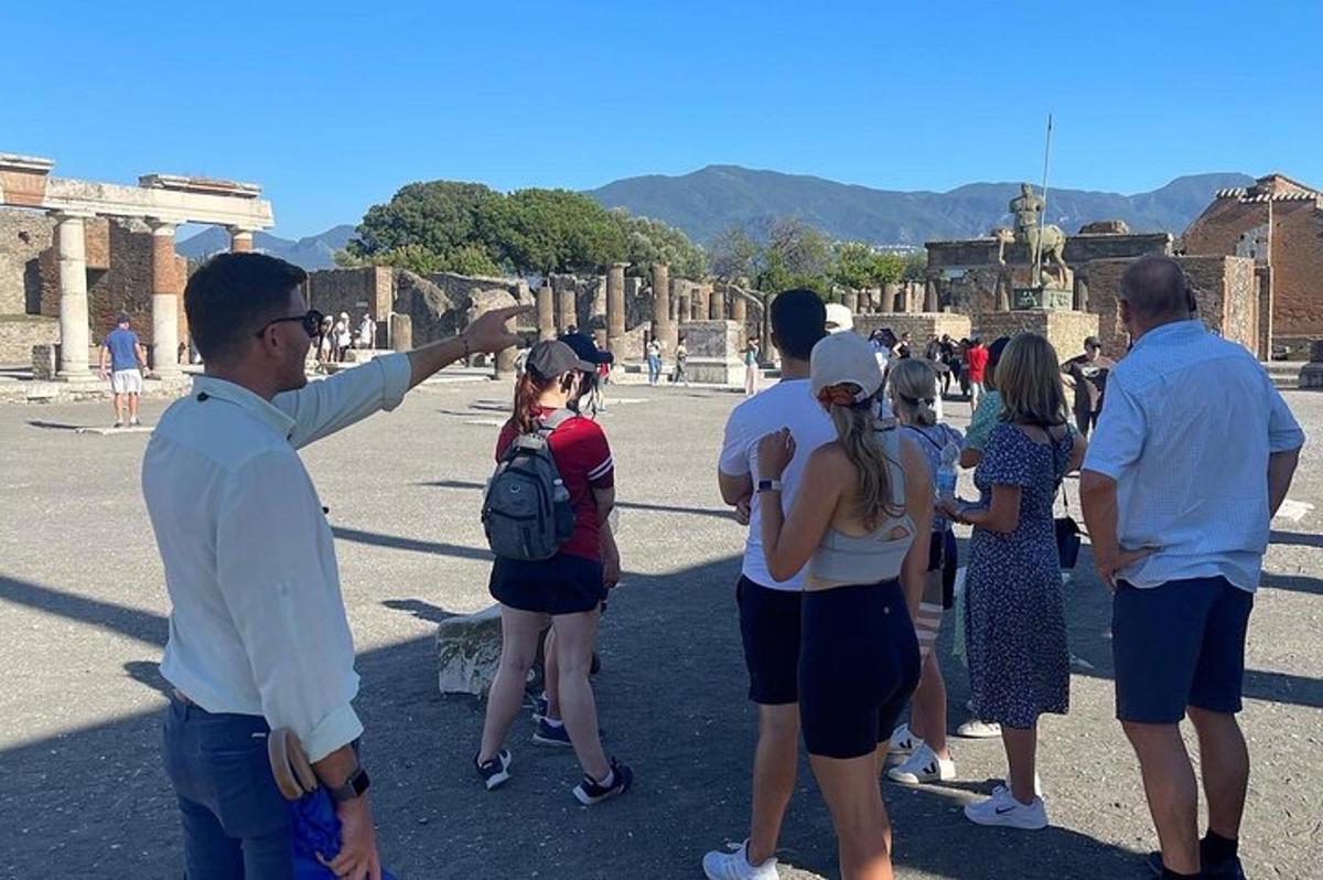 un uomo che indica un gruppo di persone tra le rovine