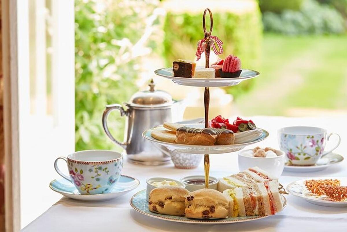 a table topped with plates of pastries and cups of tea