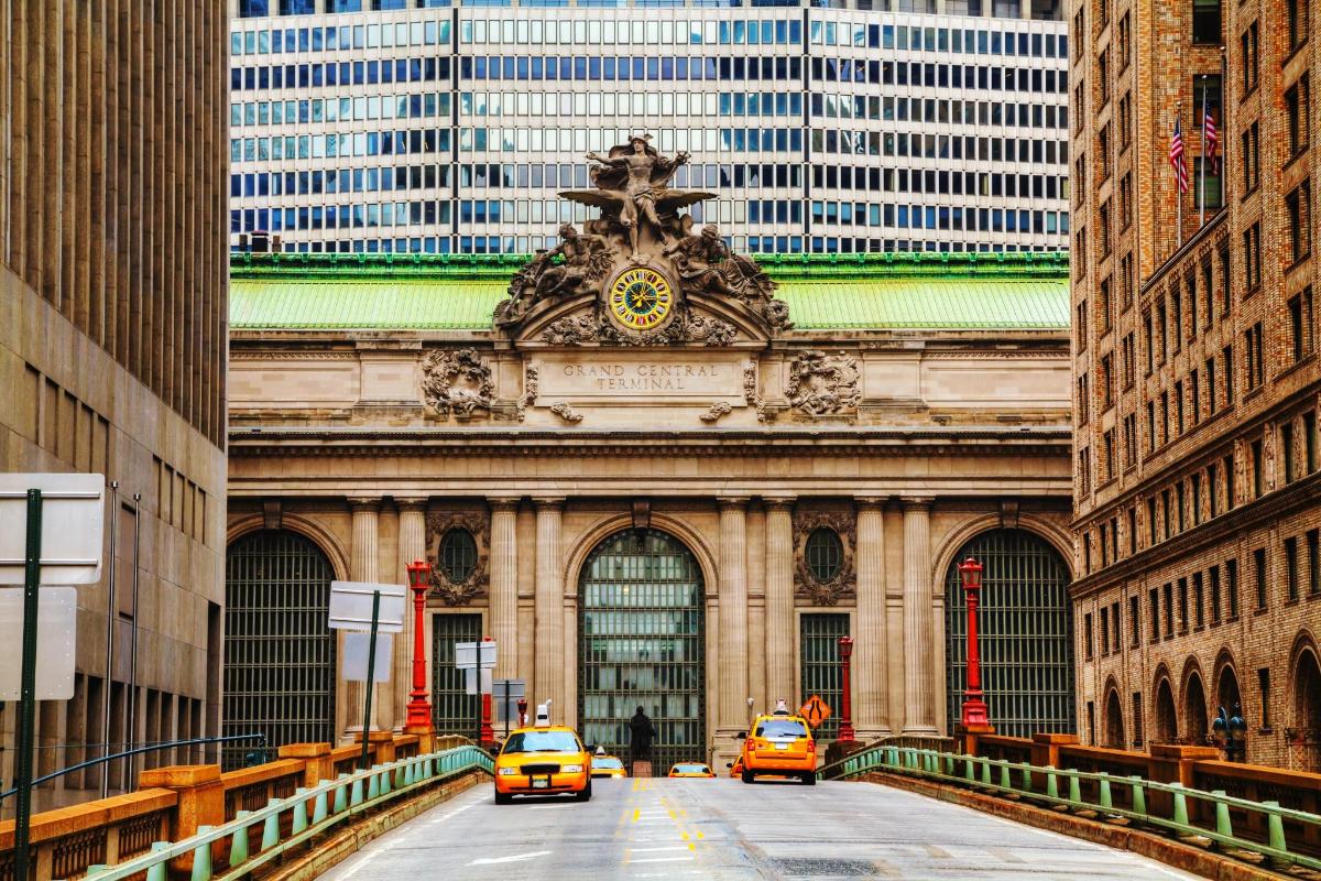 two taxis driving down a street in front of a building