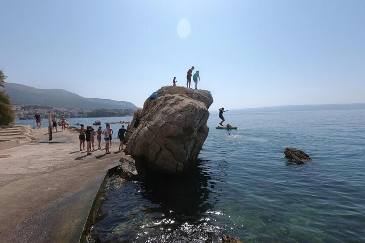 a group of people on a rock in the water