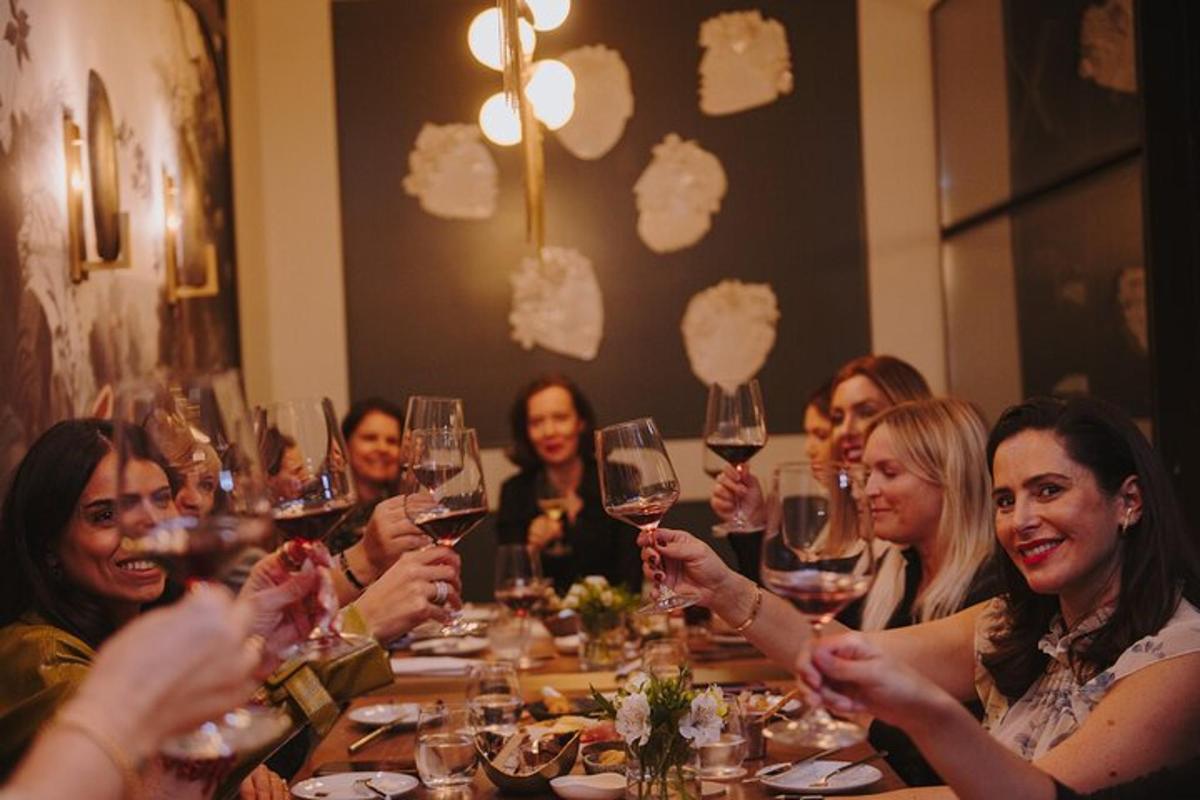 un gruppo di donne sedute attorno a un tavolo con bicchieri di vino