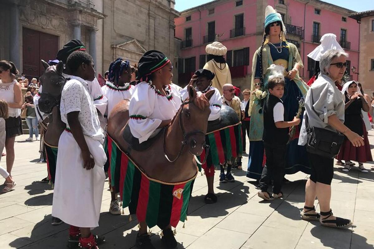 Un grupo de personas de pie alrededor de un caballo en una calle.