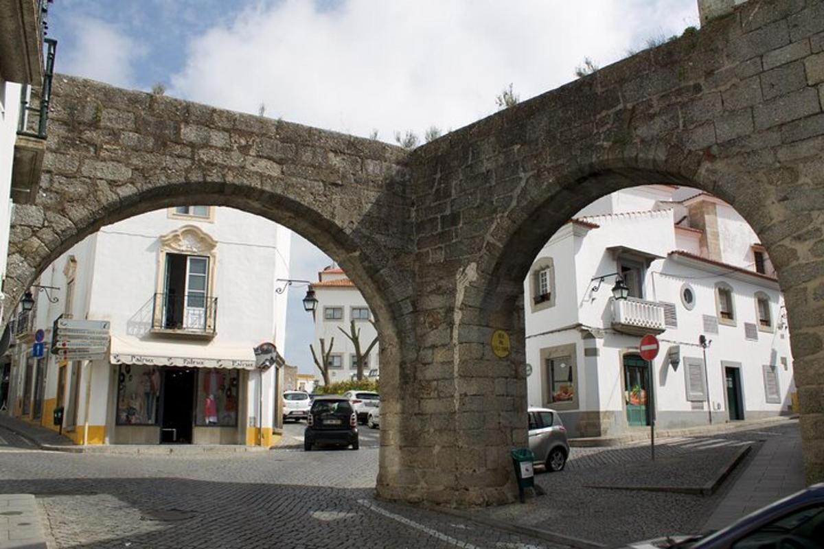 an old stone bridge with two arches on a city street