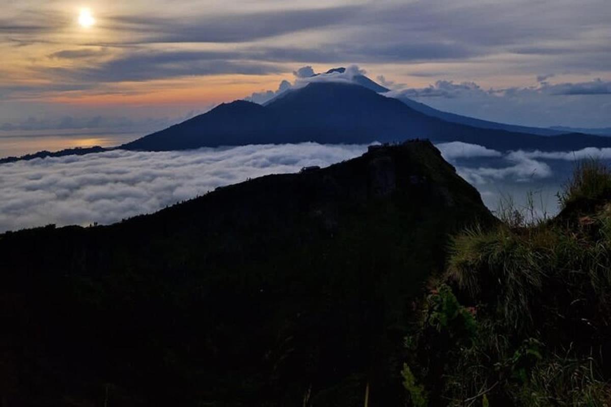 una vista di una montagna con uno strato di nuvole