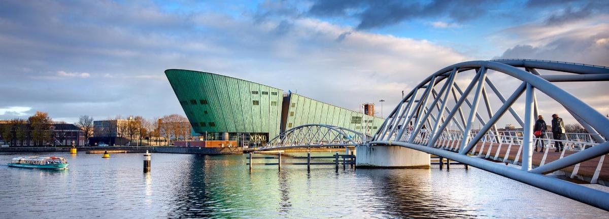 a bridge over the water in front of a building