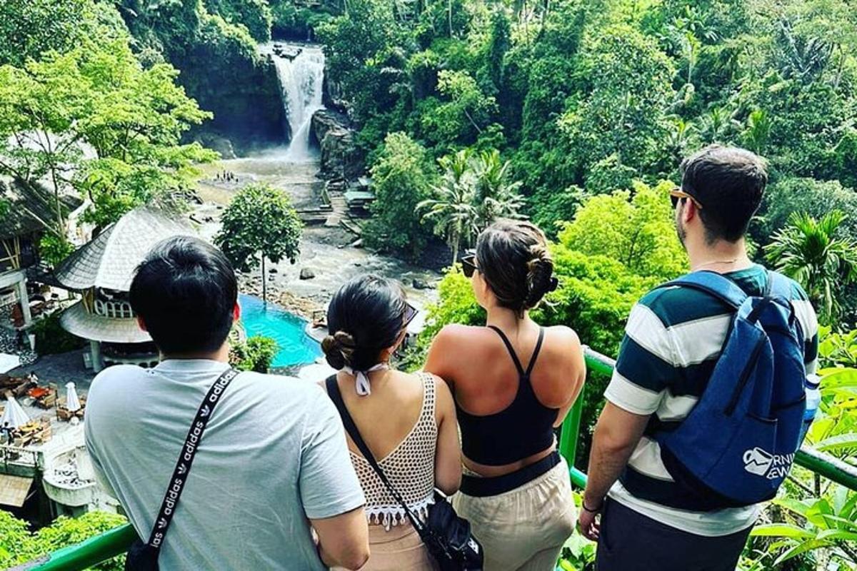 sekumpulan orang berdiri di hadapan air terjun