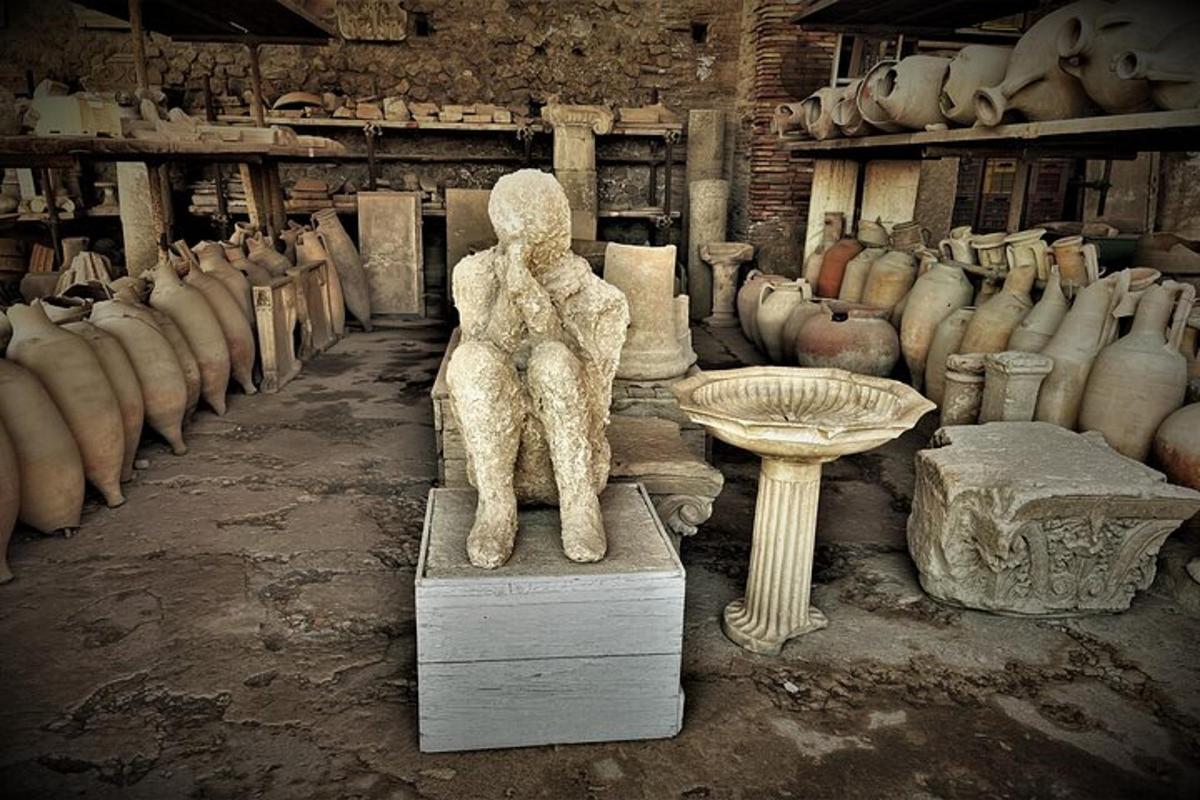 Una estatua de un oso sentado en una mesa en una habitación con jarrones.