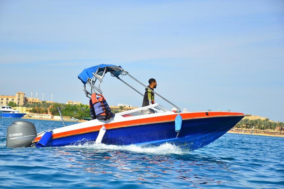 Un hombre en un bote azul y naranja en el agua.
