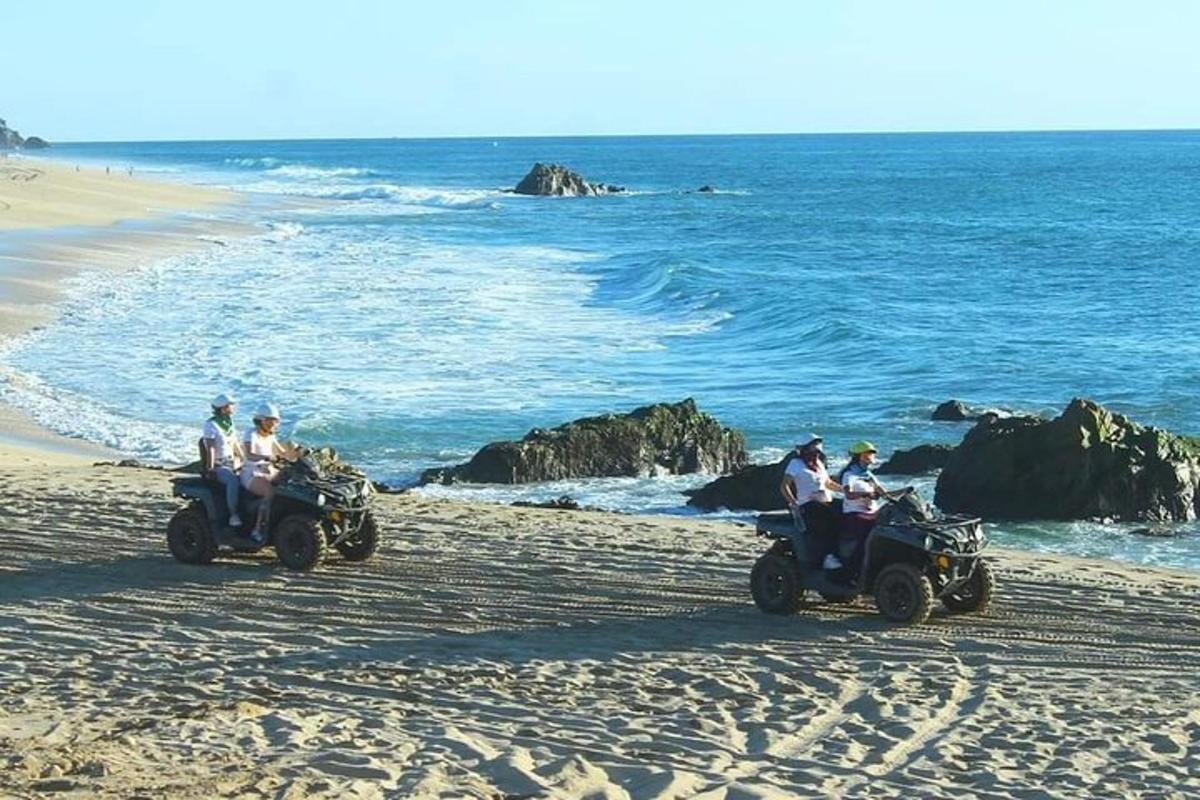 a group of people riding atvs on the beach