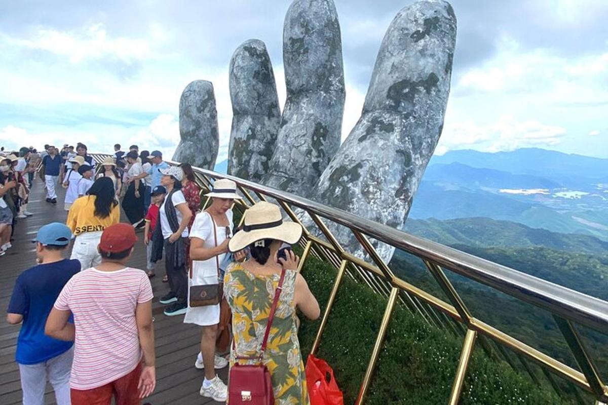 một đám đông đang nhìn vào bức tượng bàn tay