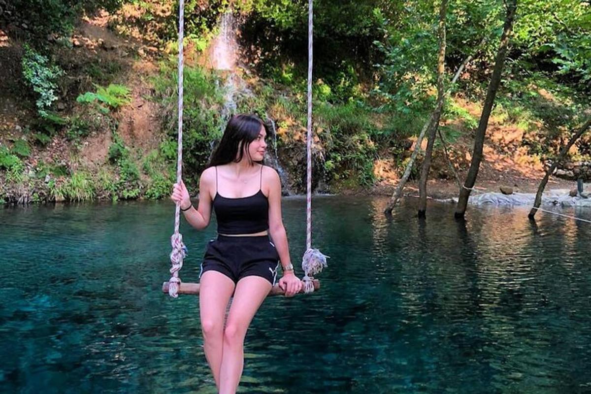 a woman sitting on a swing in the water