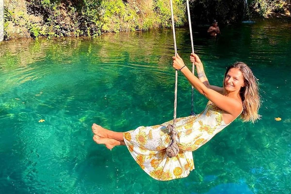 a woman on a rope swing in the water