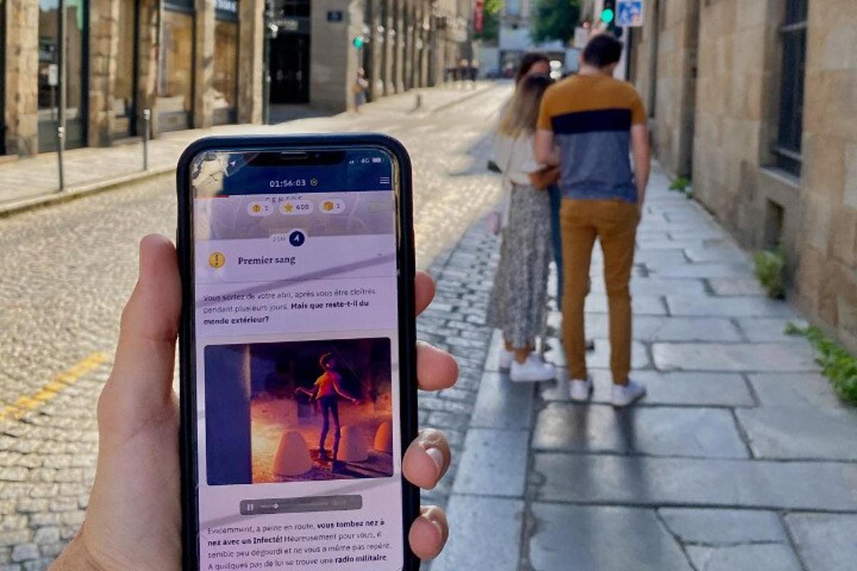 a person holding up a cell phone in a street
