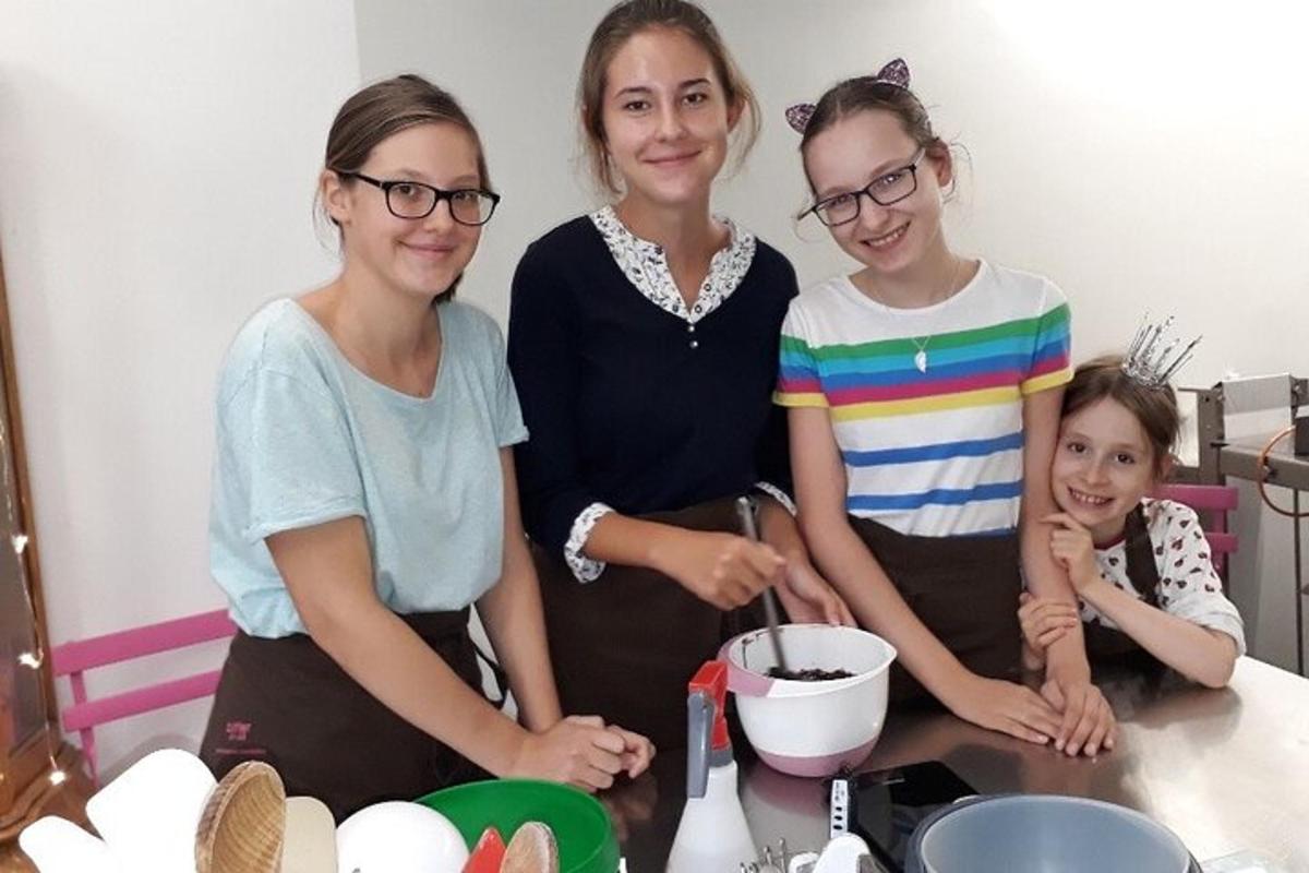 μια ομάδα τριών γυναικών που στέκονται σε μια κουζίνα