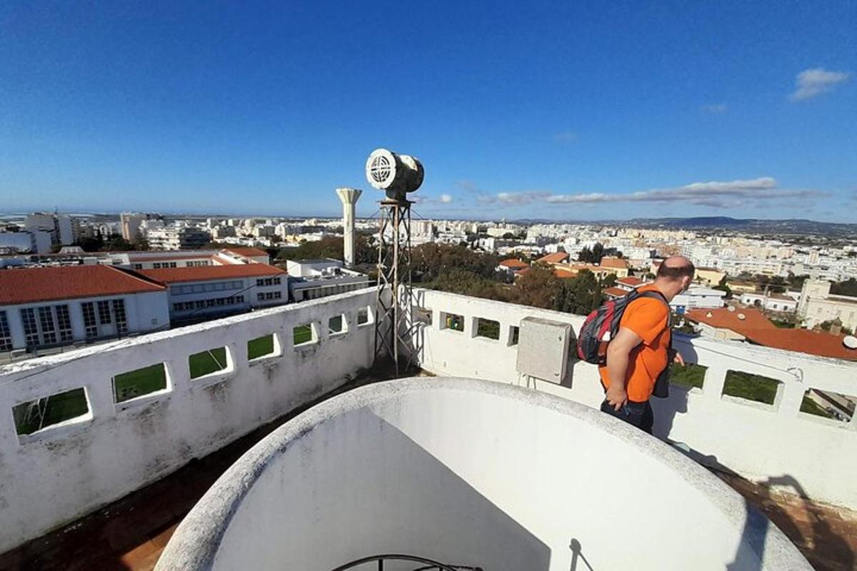 Un hombre con una mochila de pie en la parte superior de un edificio.