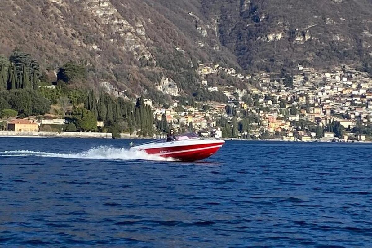 una barca rossa in mezzo a uno specchio d'acqua