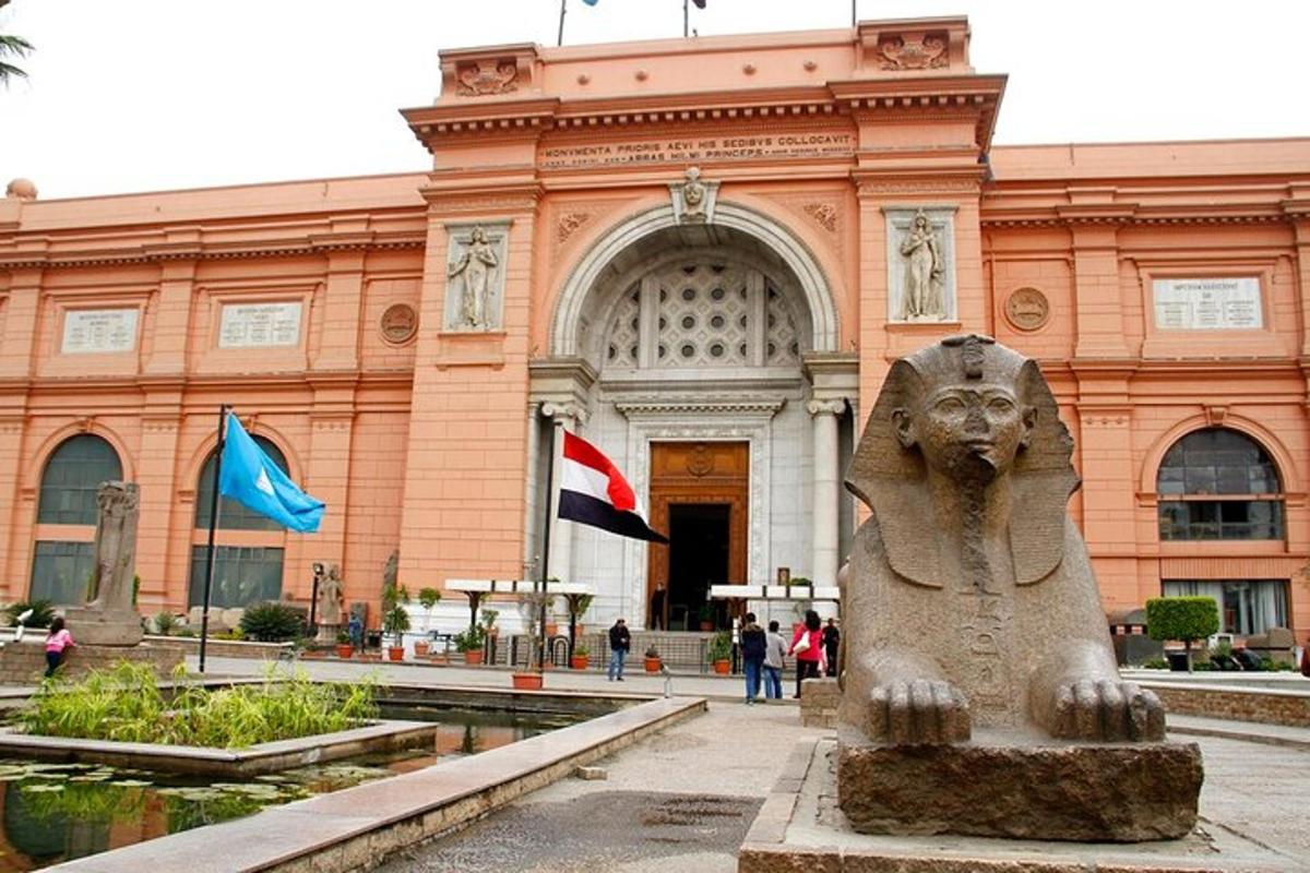 uma estátua em frente a um prédio com duas bandeiras