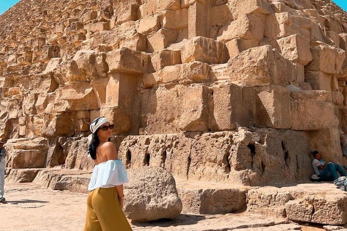 uma mulher parada em frente a uma parede de pedra