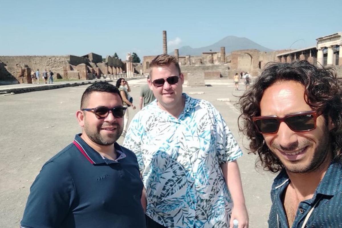 un gruppo di tre uomini in piedi davanti a un edificio