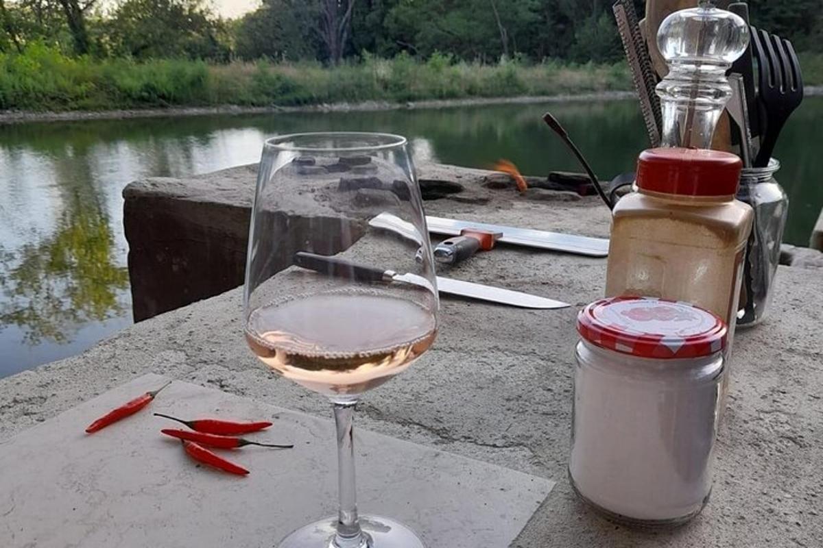 sklenice vína stojící na stole vedle lahve