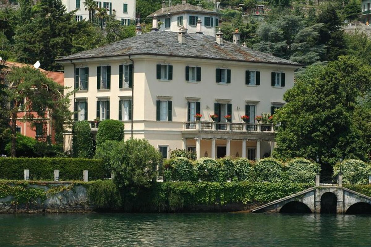 una gran casa blanca amb un pont sobre una massa d'aigua
