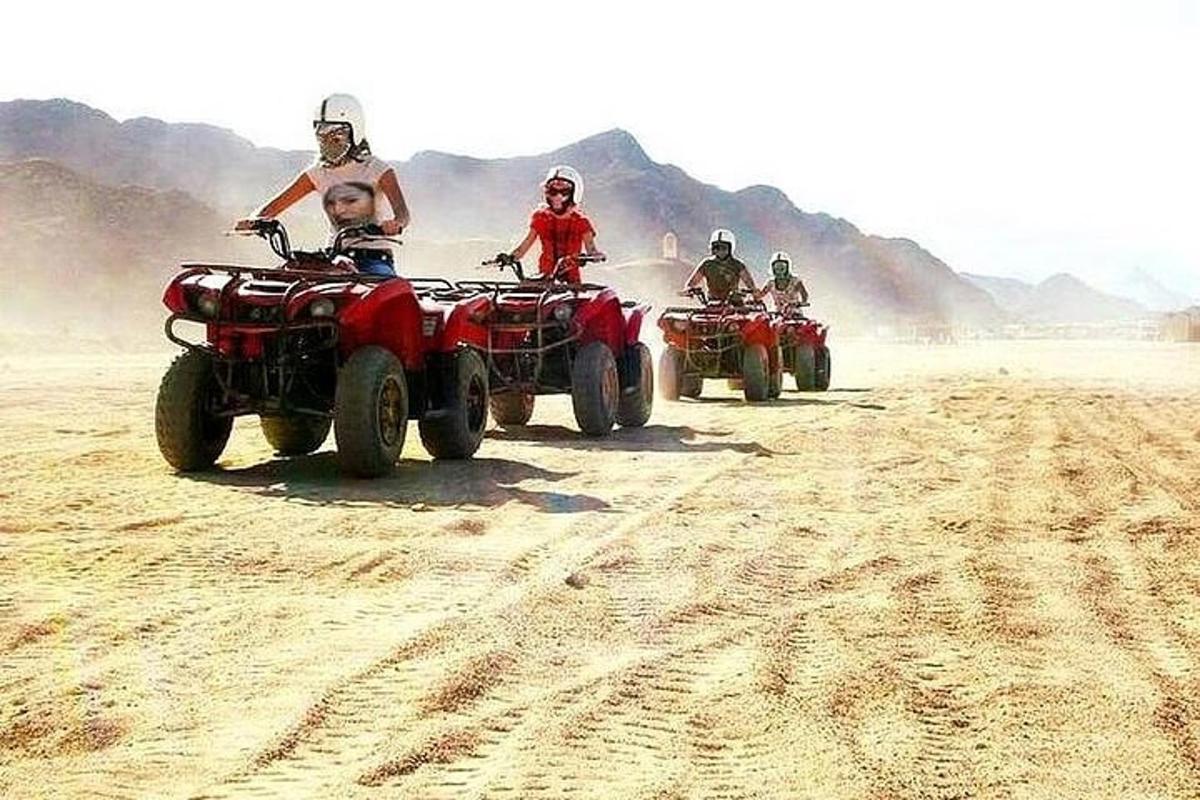 Un grupo de personas conduciendo vehículos todo terreno en el desierto.