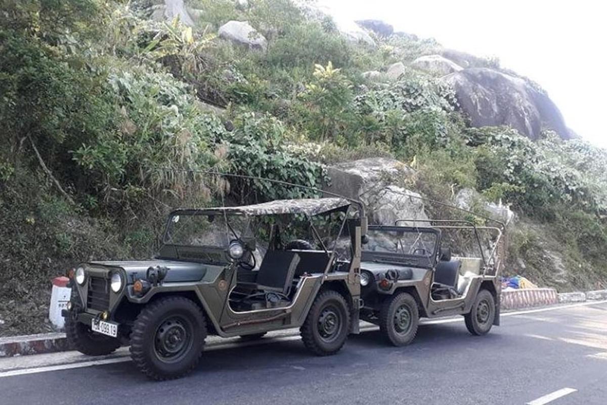 一辆军用吉普车沿着山边的道路行驶