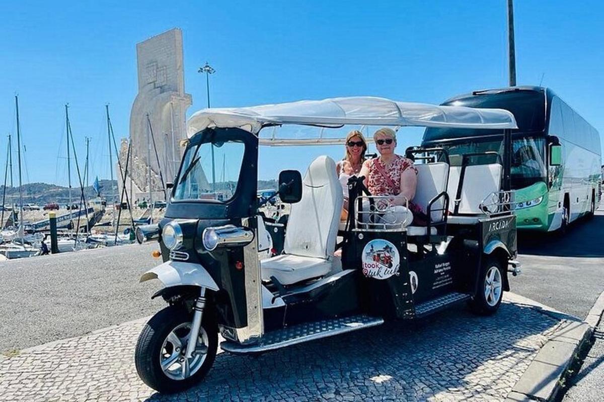 dvě ženy jedoucí na golfovém vozíku s autobusem