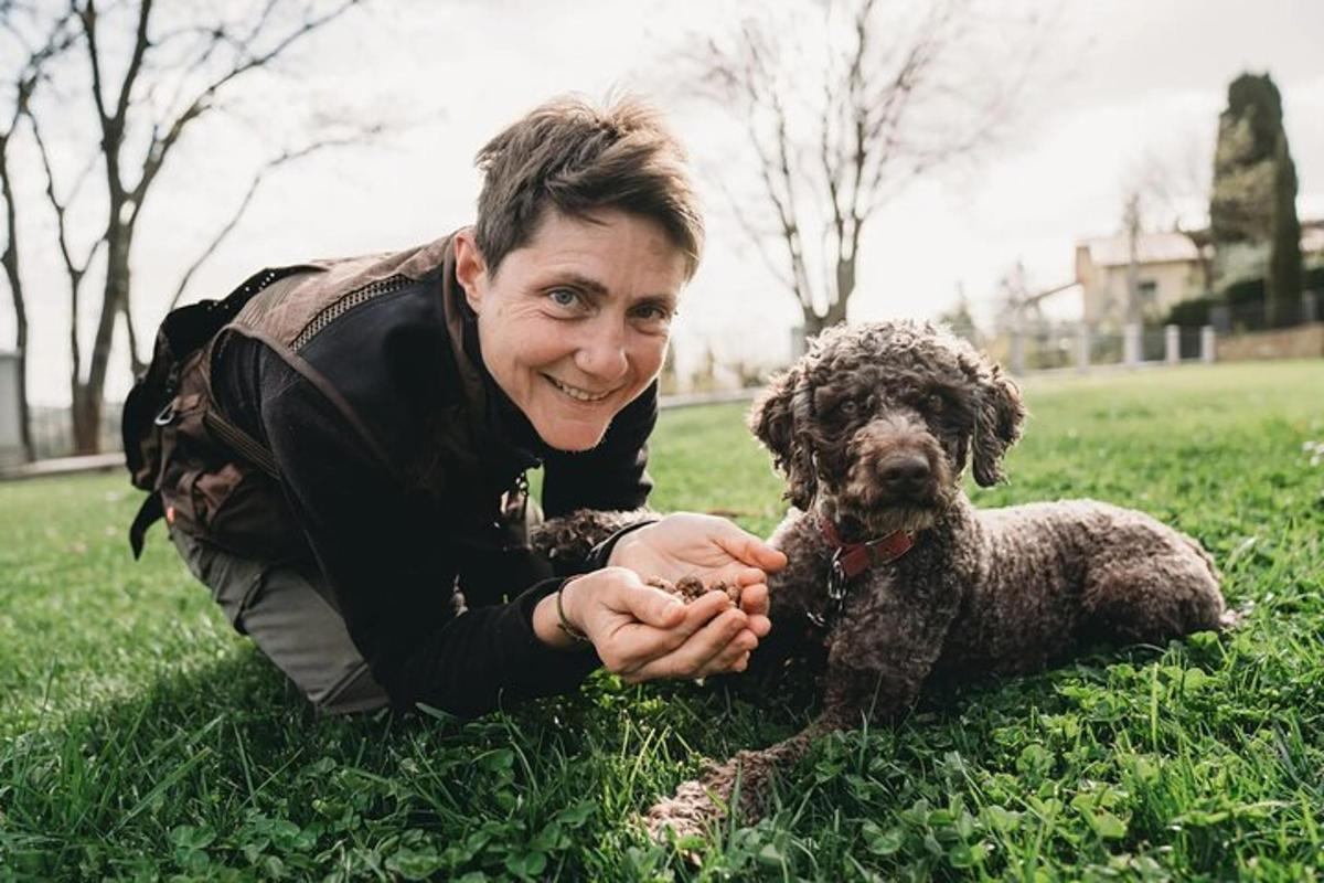una donna sdraiata sull'erba con un cane
