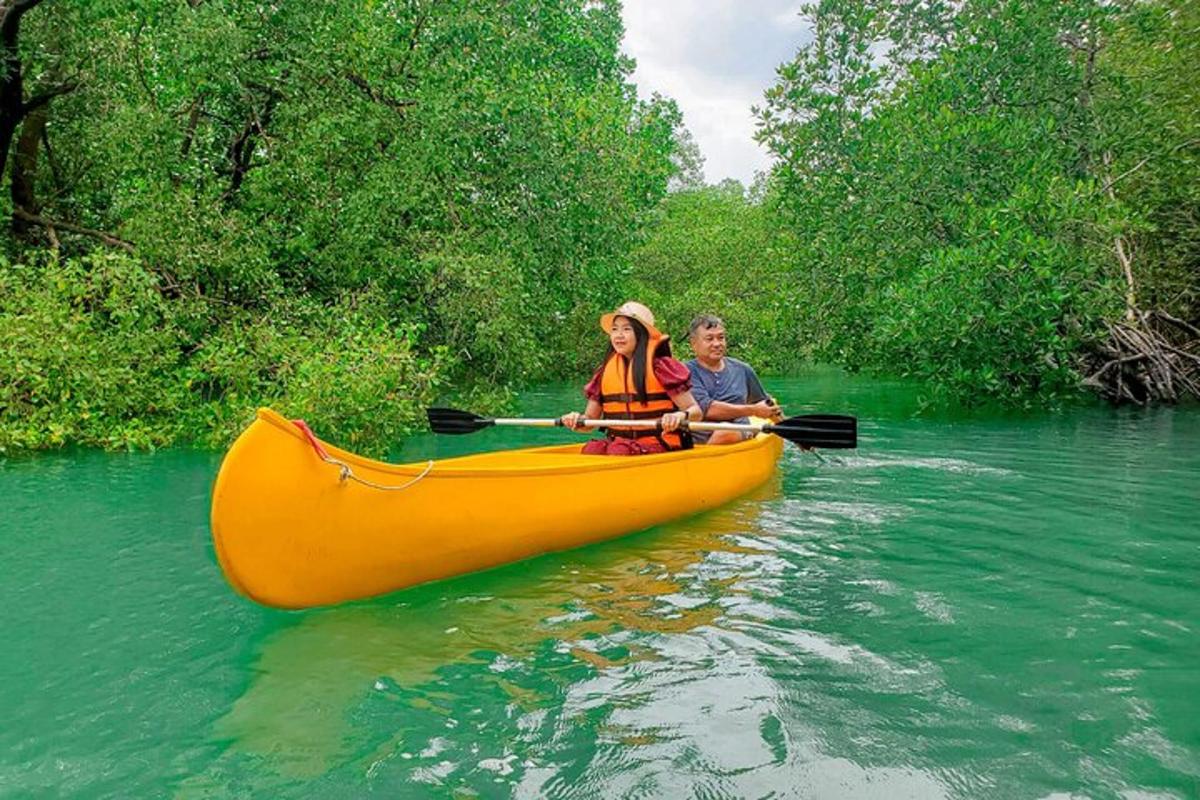 um homem e uma mulher em uma canoa amarela em um rio