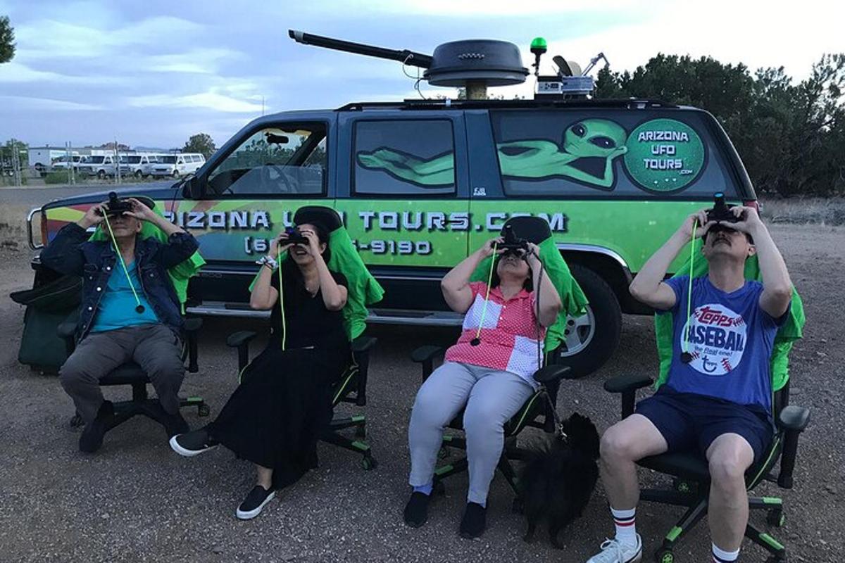un grup de persones fent fotos davant d'un vehicle