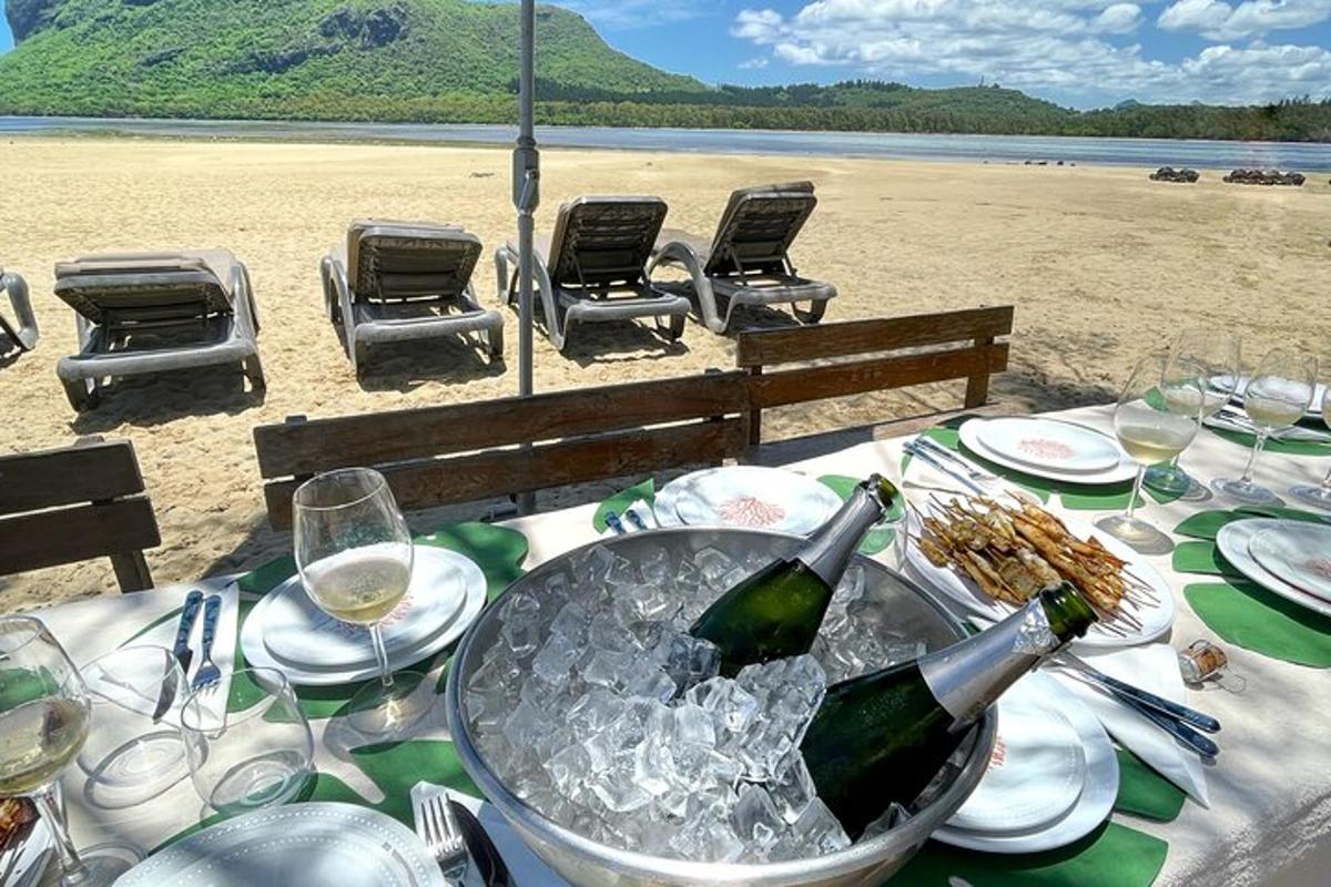 uma mesa com uma garrafa de vinho na praia