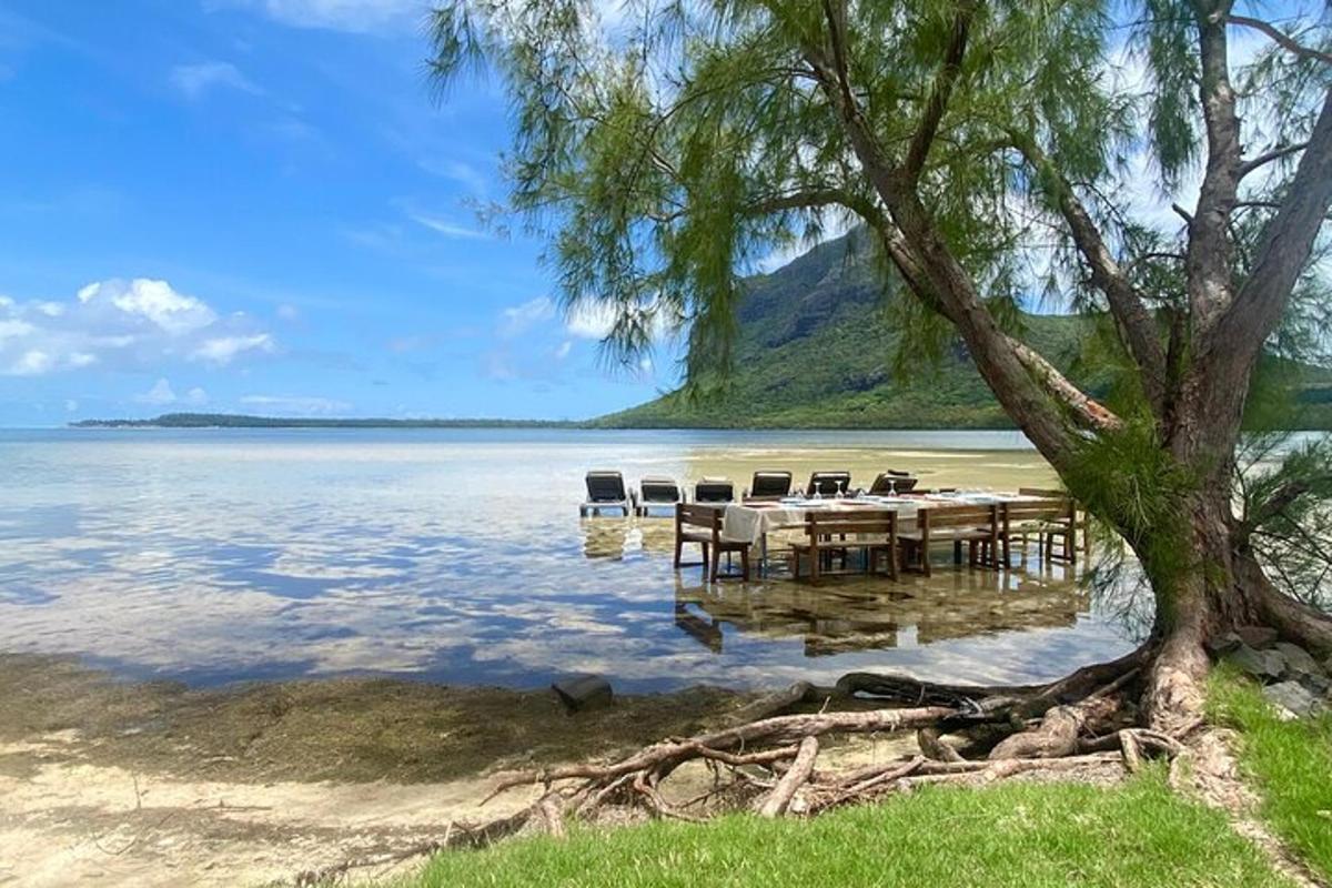 uma praia com uma mesa e cadeiras na água