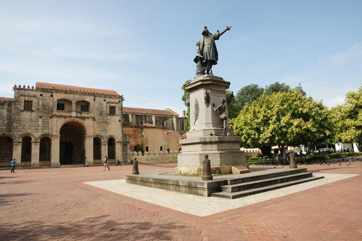 a statue in the middle of a courtyard with a building