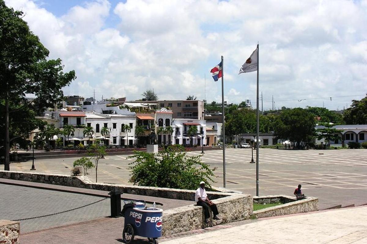 a man sitting on a wall next to two flags