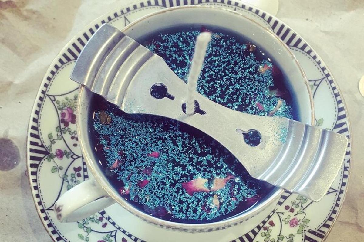a cup filled with blueberries and a fork on a plate