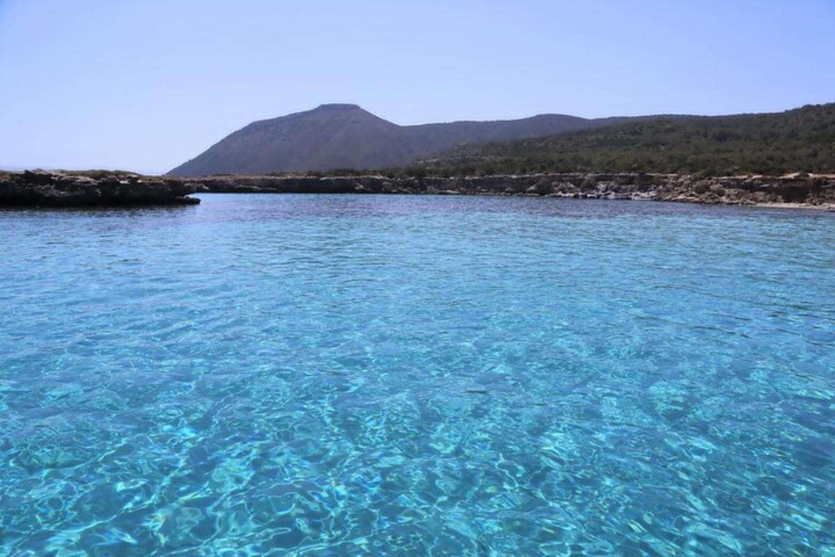 a large body of blue water with mountains in the background