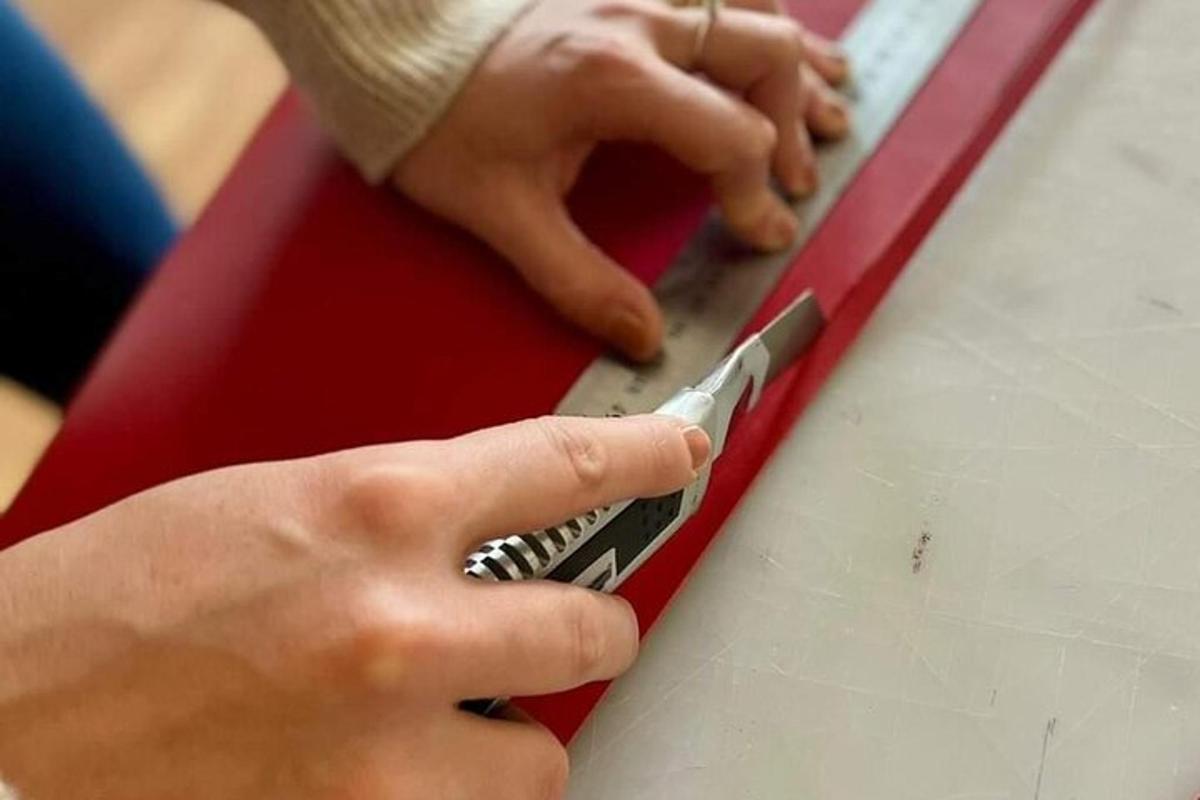 osoba stříhající kus papíru nůžkami
