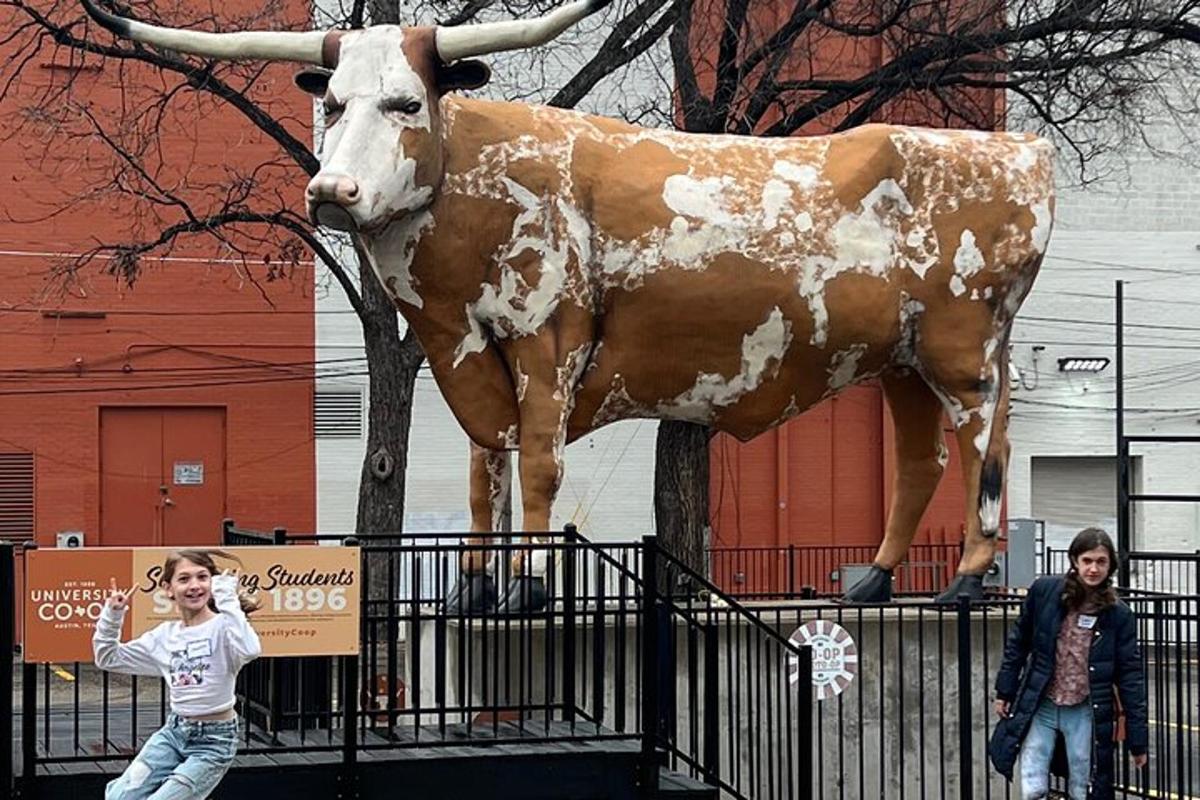 a woman standing in front of a statue of a cow
