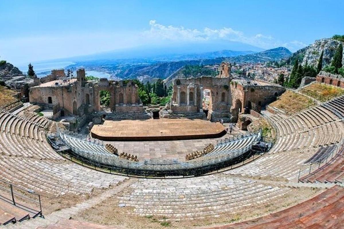 un antico anfiteatro con le montagne sullo sfondo