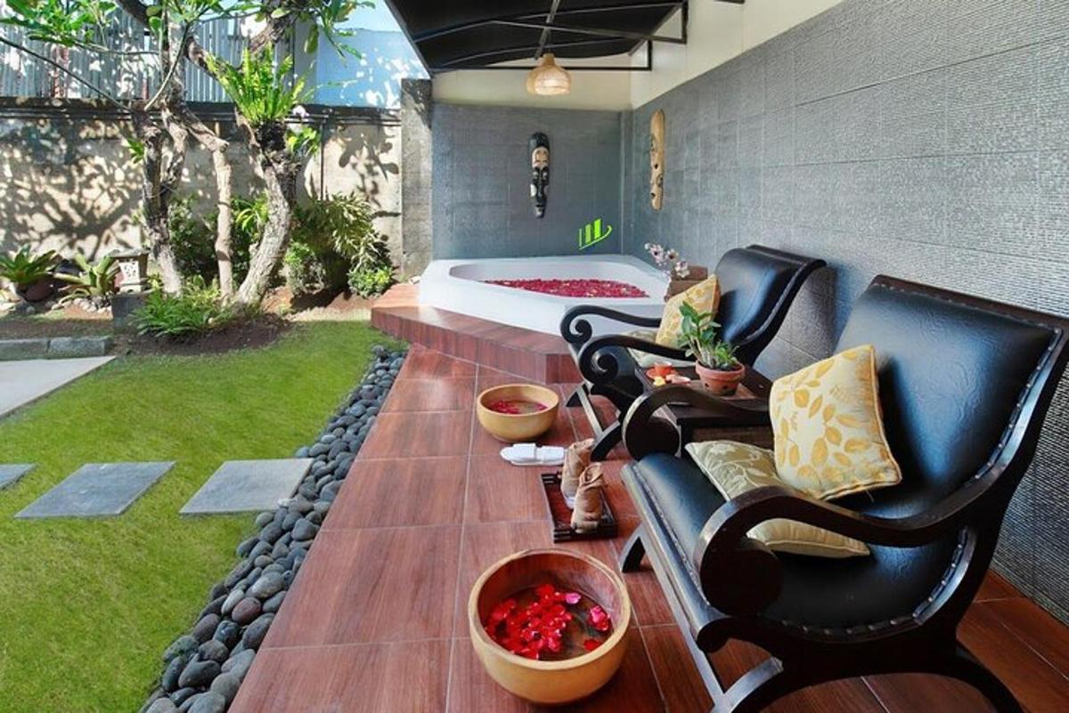 a patio with a couch and a bed and grass