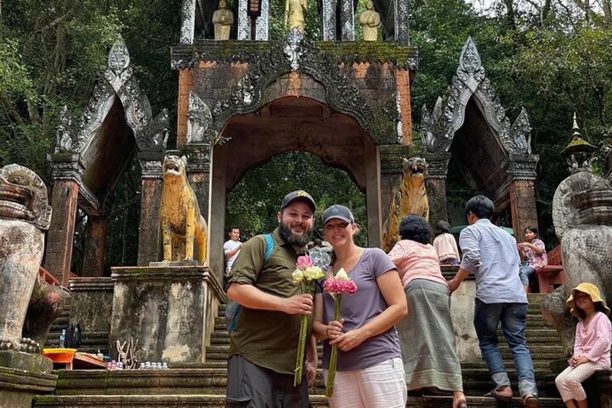 en mand og kvinde holder blomster foran et tempel