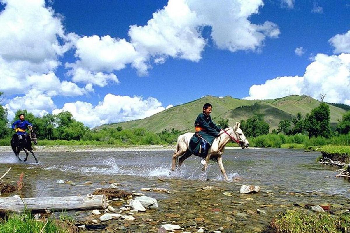 two people riding horses through a river