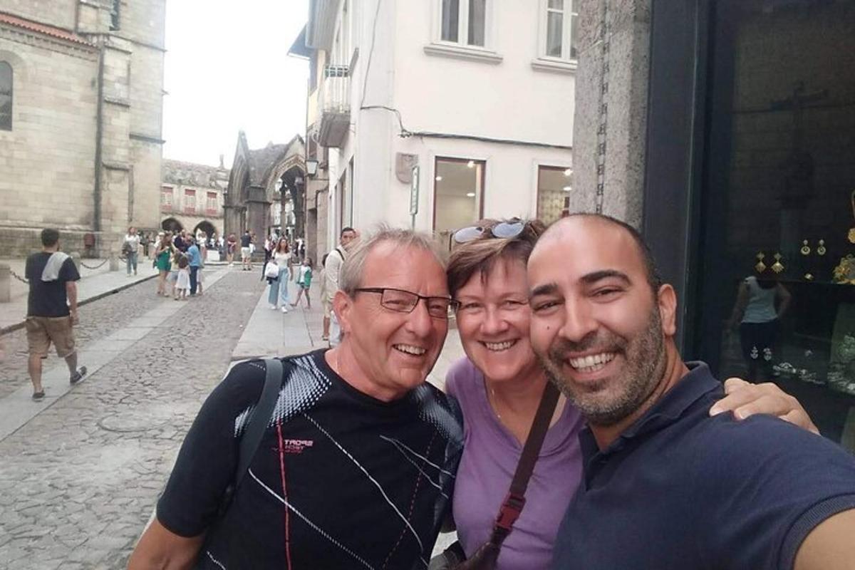 two men and a woman posing for a picture on a street